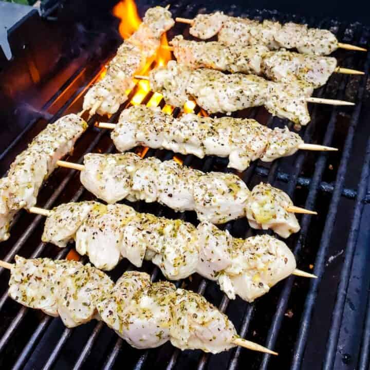 Chicken souvlaki kebabs cooking on a grill.