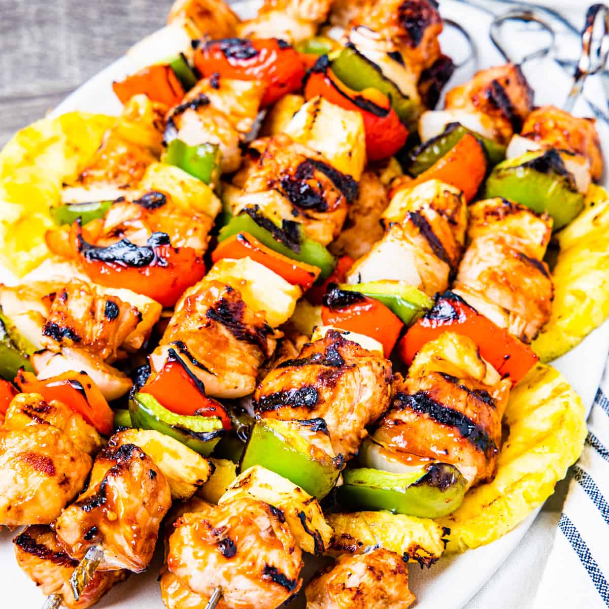 Grilled Hawaiian chicken kebabs served on a platter.