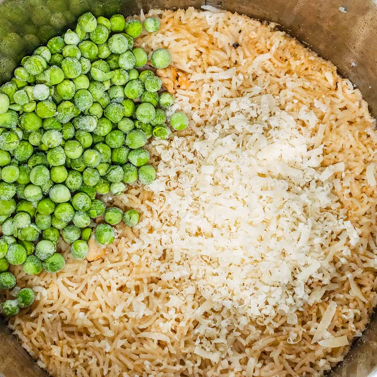 Instant pot chicken and rice shown after pressure cooking and adding the peas and cheese.
