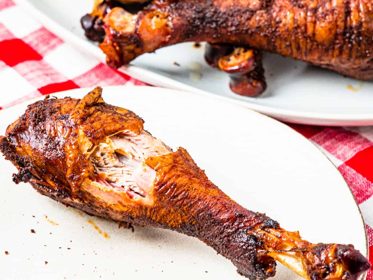 A close up of a smoked turkey leg with a bite taken from the center. 