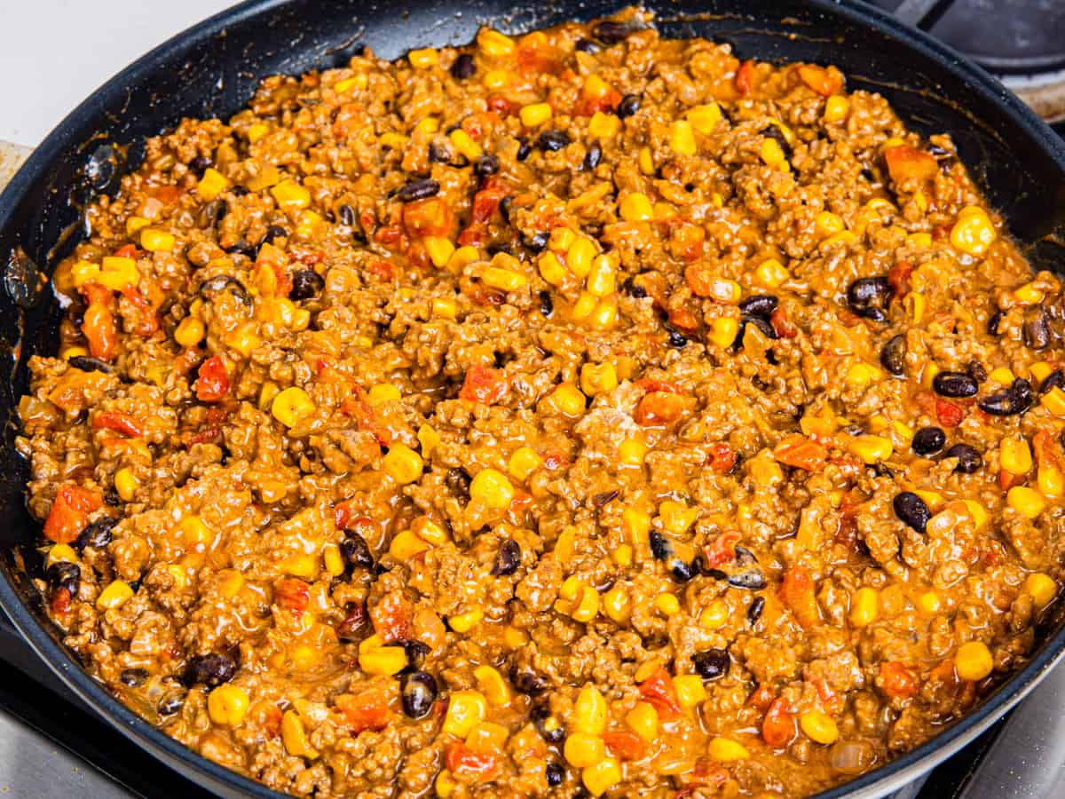 The finished taco casserole is shown in a skillet after stirring in the sour cream and cheese. 
