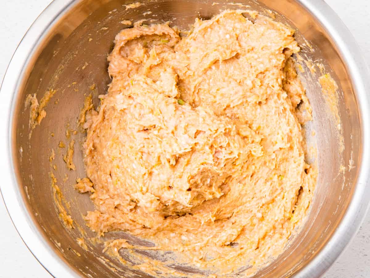 The meatball mixture is shown in a large mixing bowl after being thoroughly combined. 