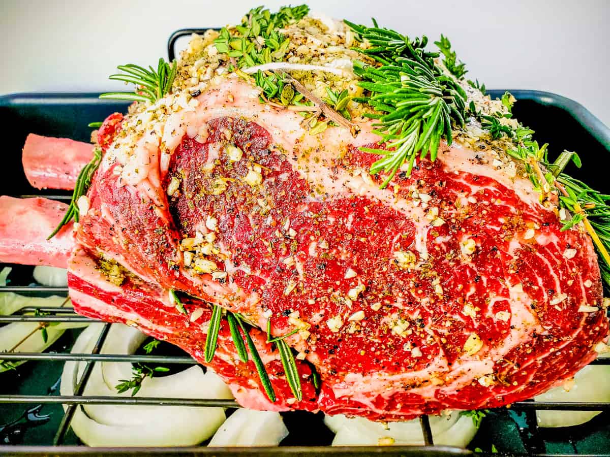 https://disheswithdad.com/wp-content/uploads/2022/10/standing-rib-roast-with-garlic-and-herbs-in-roasting-pan.jpg