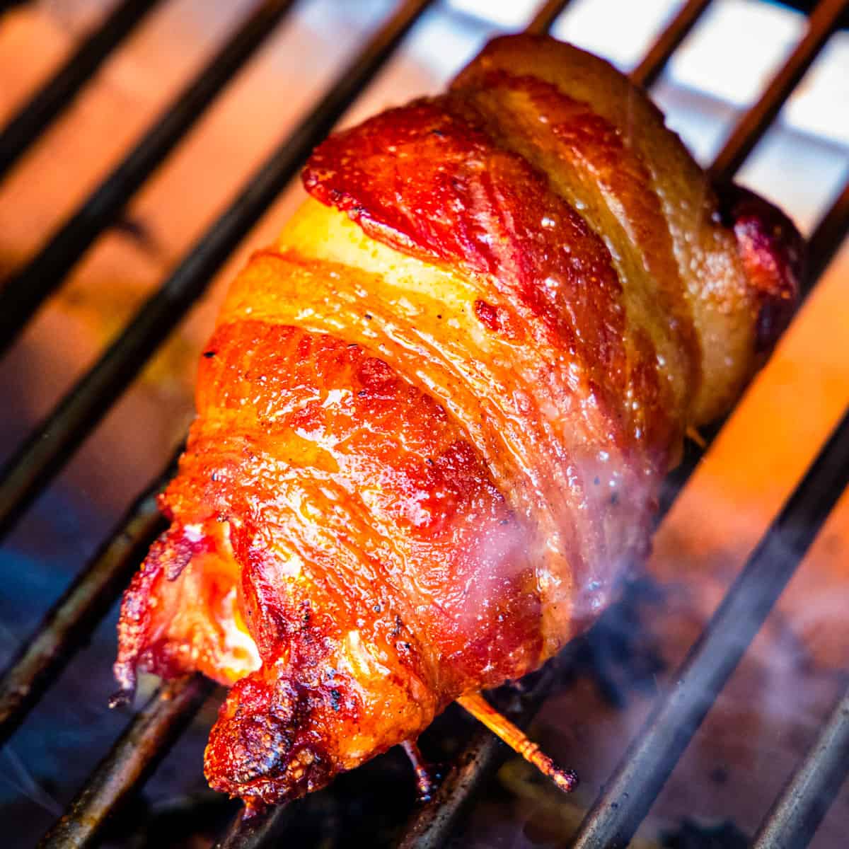 Smoked chicken thighs wrapped in bacon after cooking. 