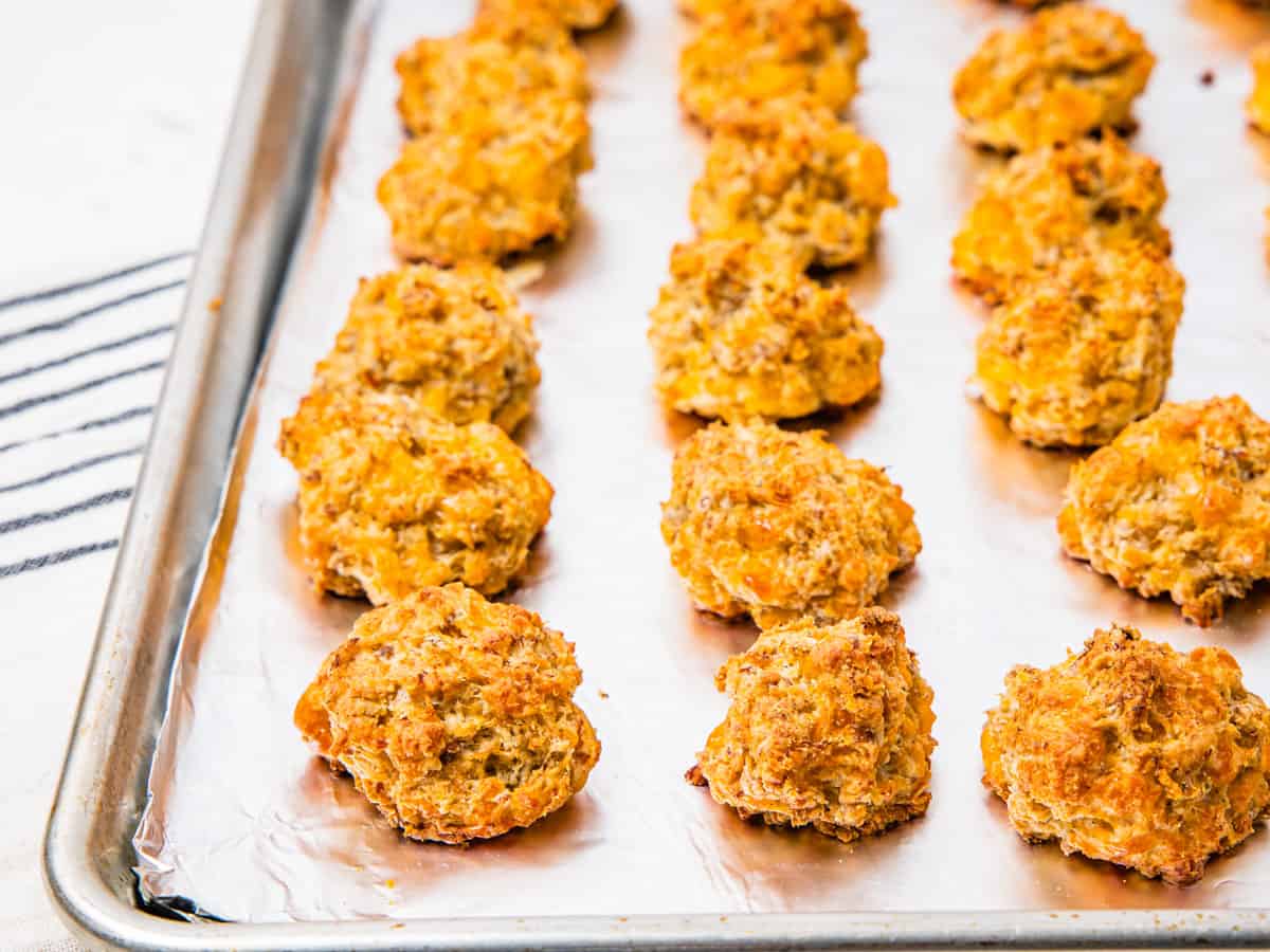 A baking sheet with rows of cooked sausage balls.