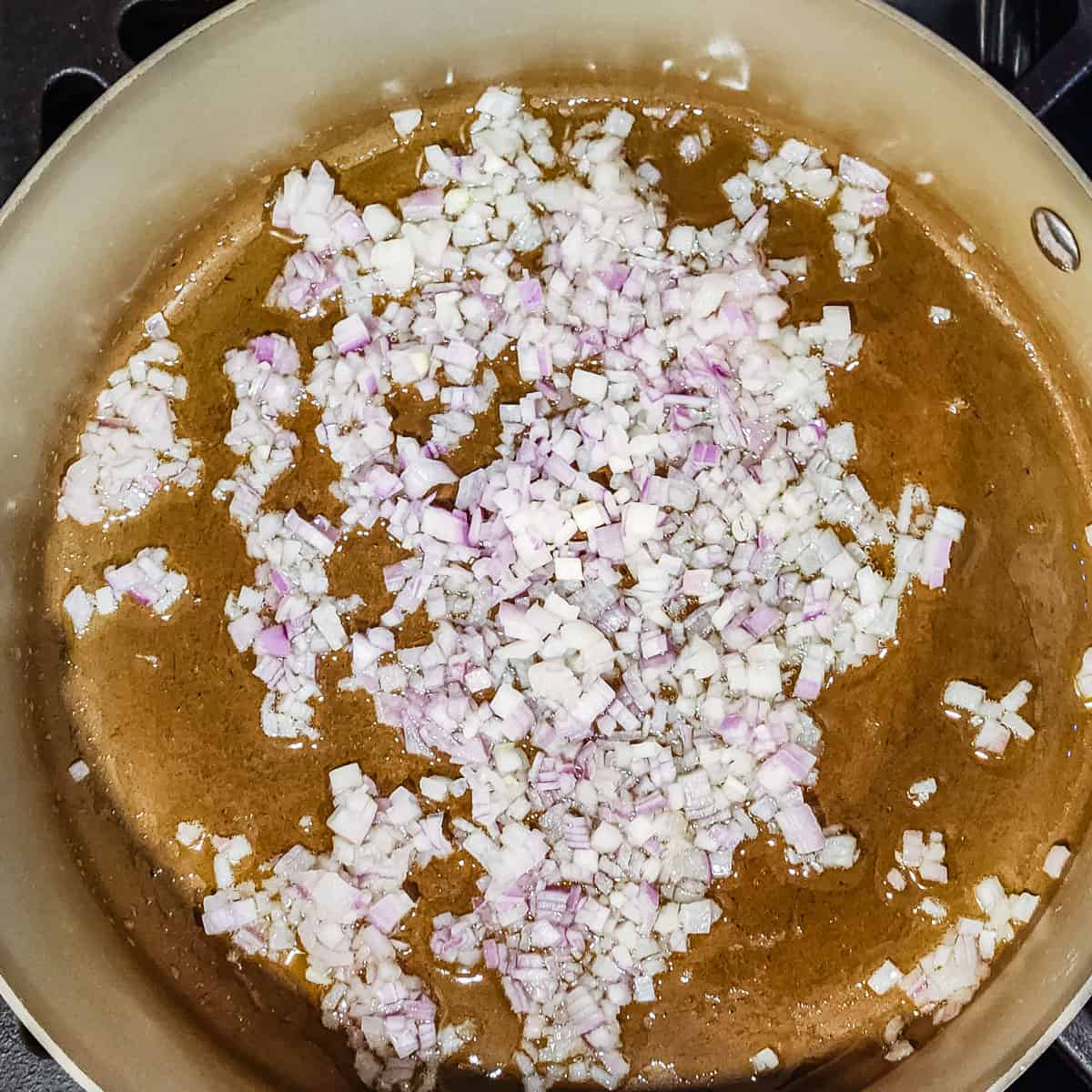 Shallots being cooked in a sauté pan.