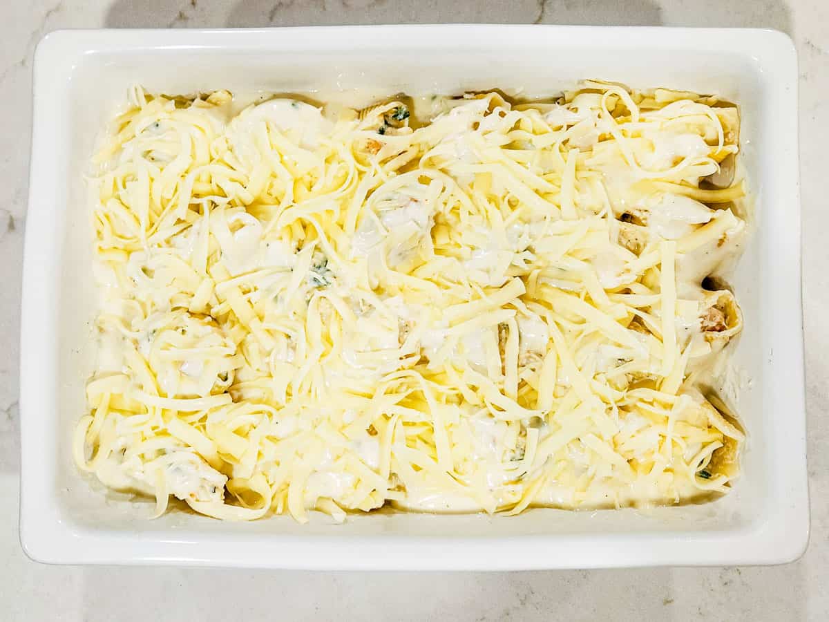 The assembled seafood stuffed shells shown topped with mozzarella cheese before being baked. 