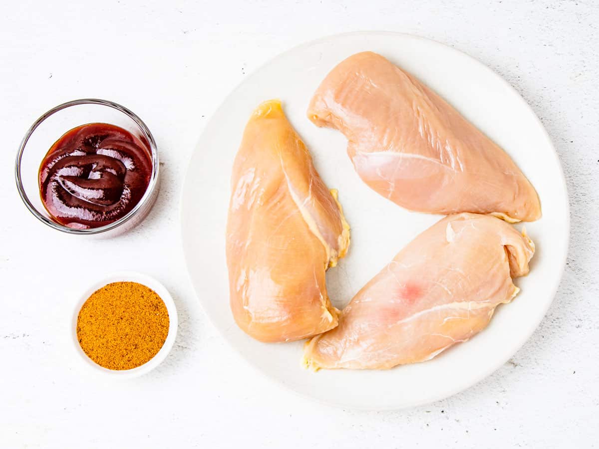 Ingredients for BBQ chicken breasts shown set out on a counter.