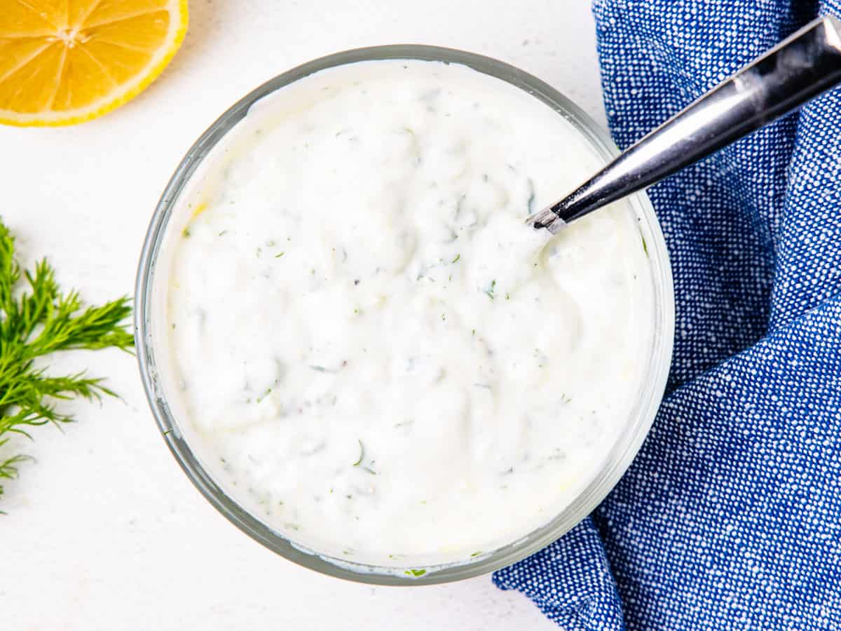 Tzatziki sauce shown in a mixing bowl after stirring together.