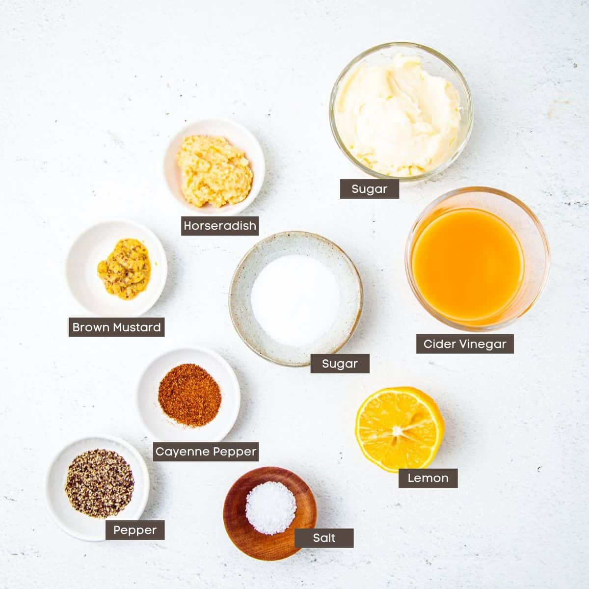 Ingredients for white bbq sauce shown on a countertop in individual bowls.