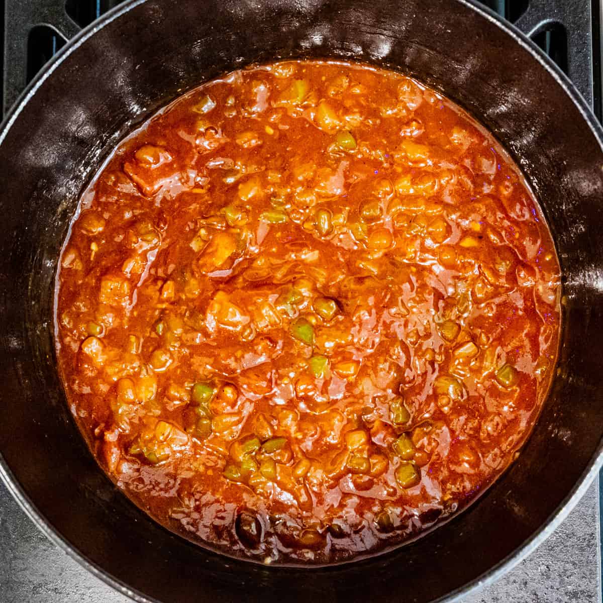 Sauce for baked beans shown in a cast iron pot.