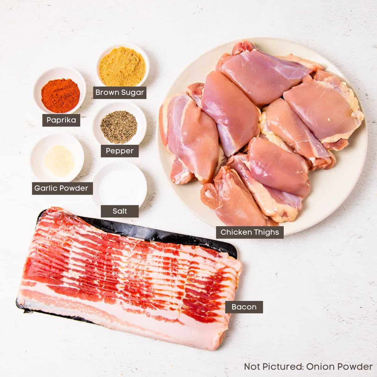 Ingredients for bacon wrapped chicken thighs shown arranged on a countertop.