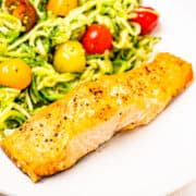 A salmon fillet served with zucchini noodles.