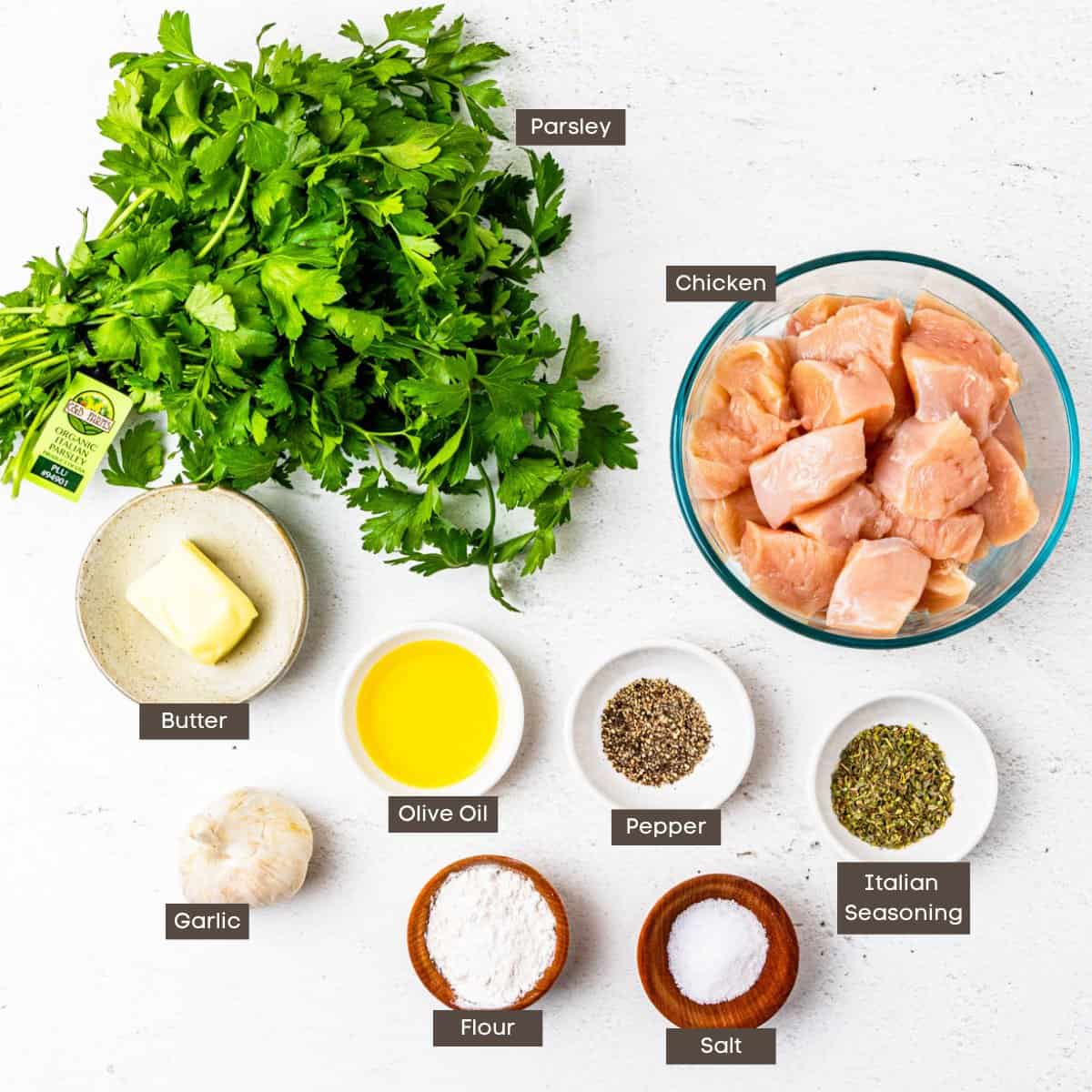 Ingredients for garlic butter chicken bites shown arranged on a counter in individual bowls.