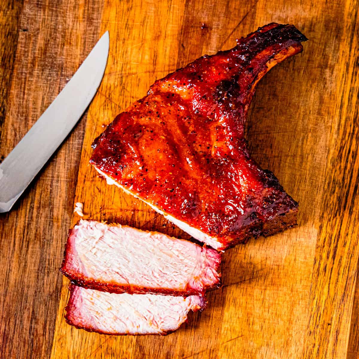 A smoked pork chop on a cutting board.