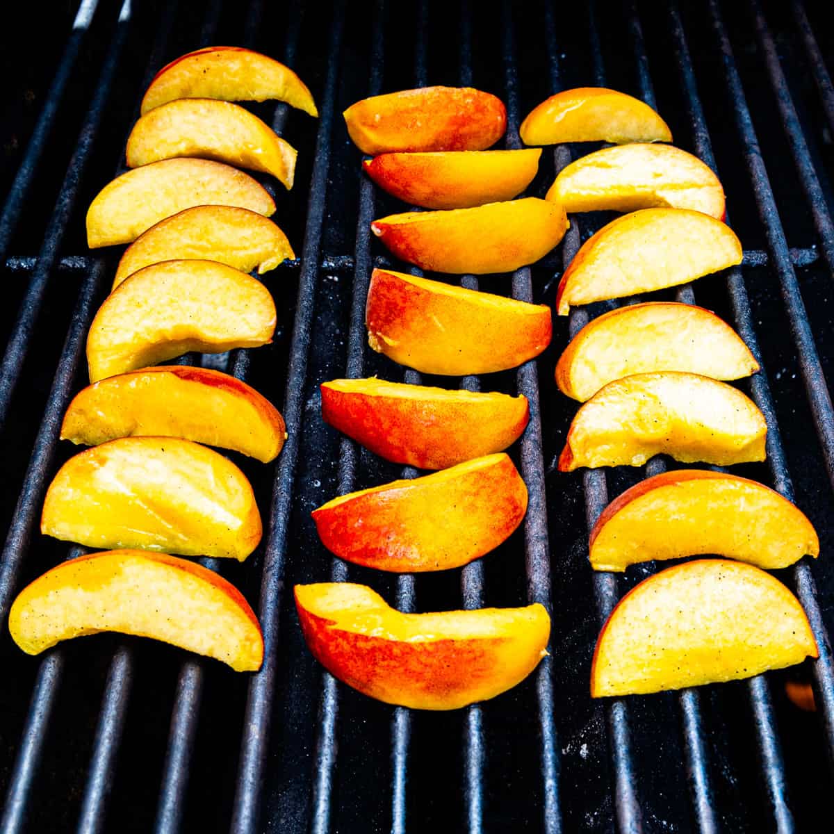 Peaches cooking on a grill.