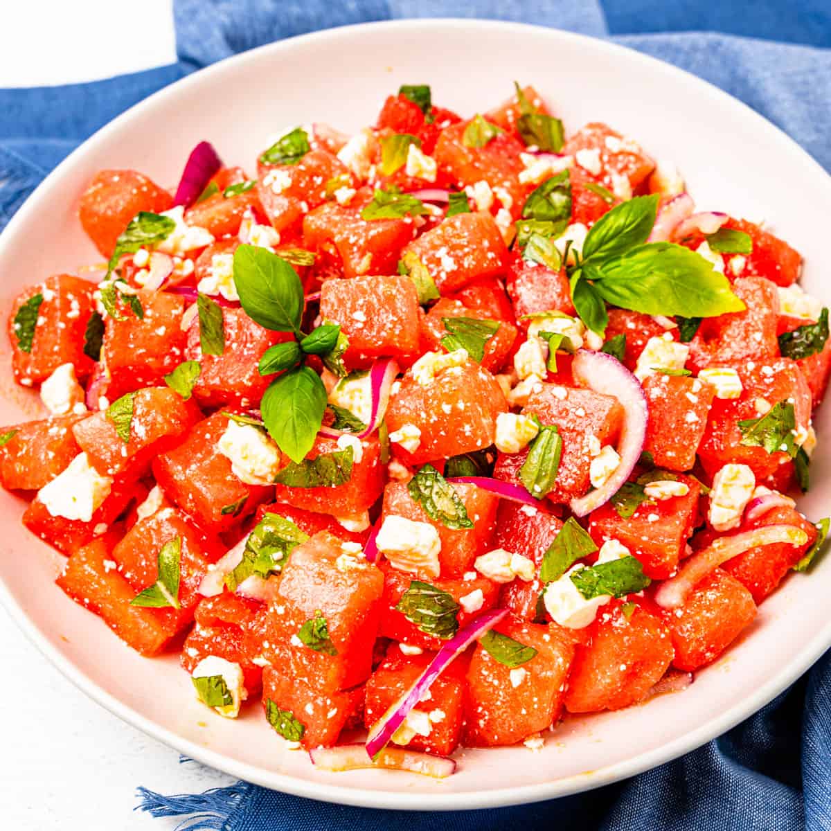 Watermelon salad with basil and feta in a large serving bowl.
