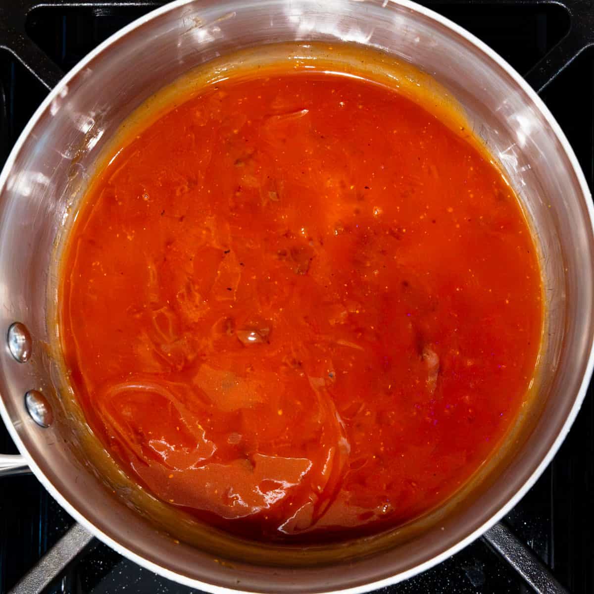 Barbecue sauce cooking in a saucepan.