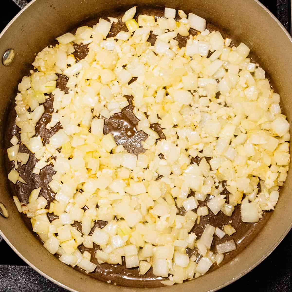 Diced onion cooking in a pan.