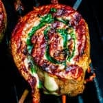 A steak pinwheel cooking on a grill.