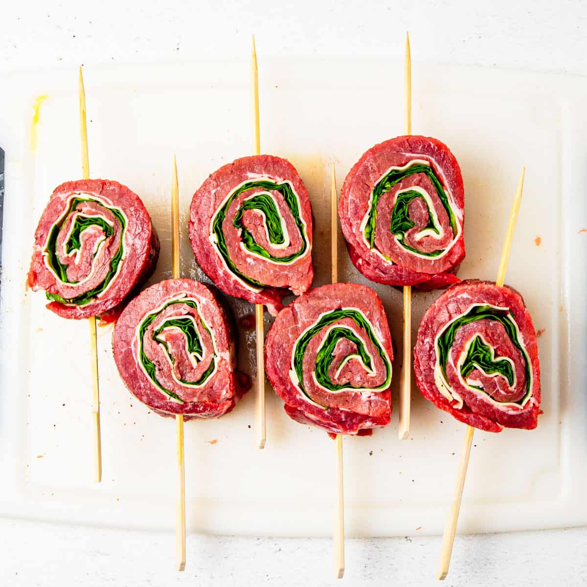 Individual pinwheels on a cutting board after being sliced.