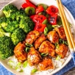 A rice bowl topped with teriyaki chicken, steamed broccoli, and sautéed peppers.