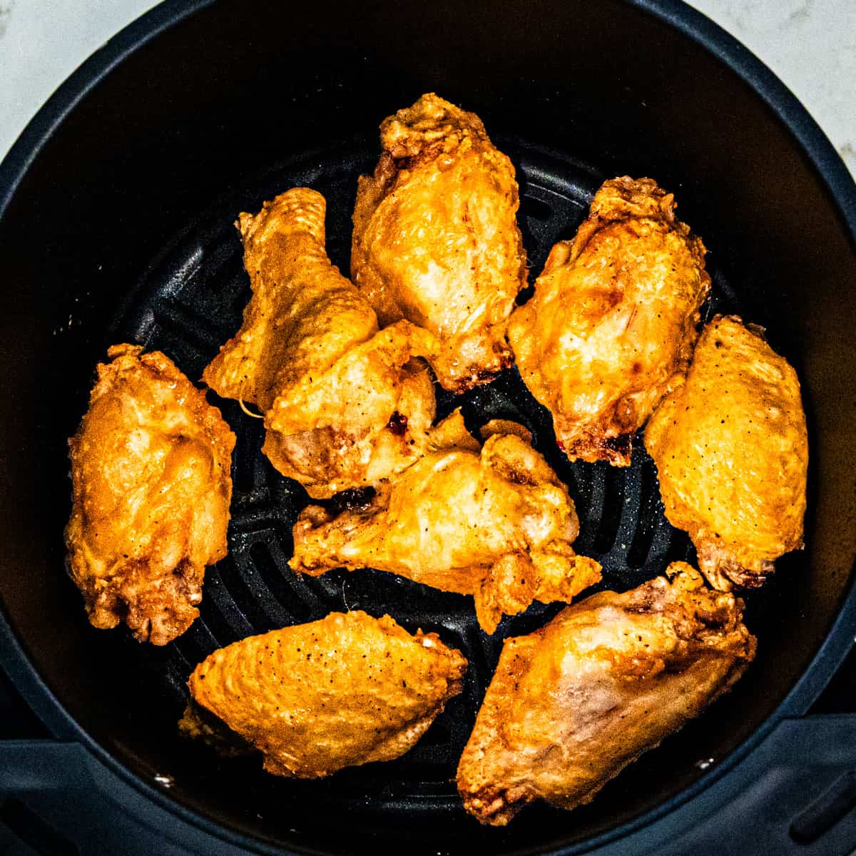 Chicken wings in an air fryer after cooking.