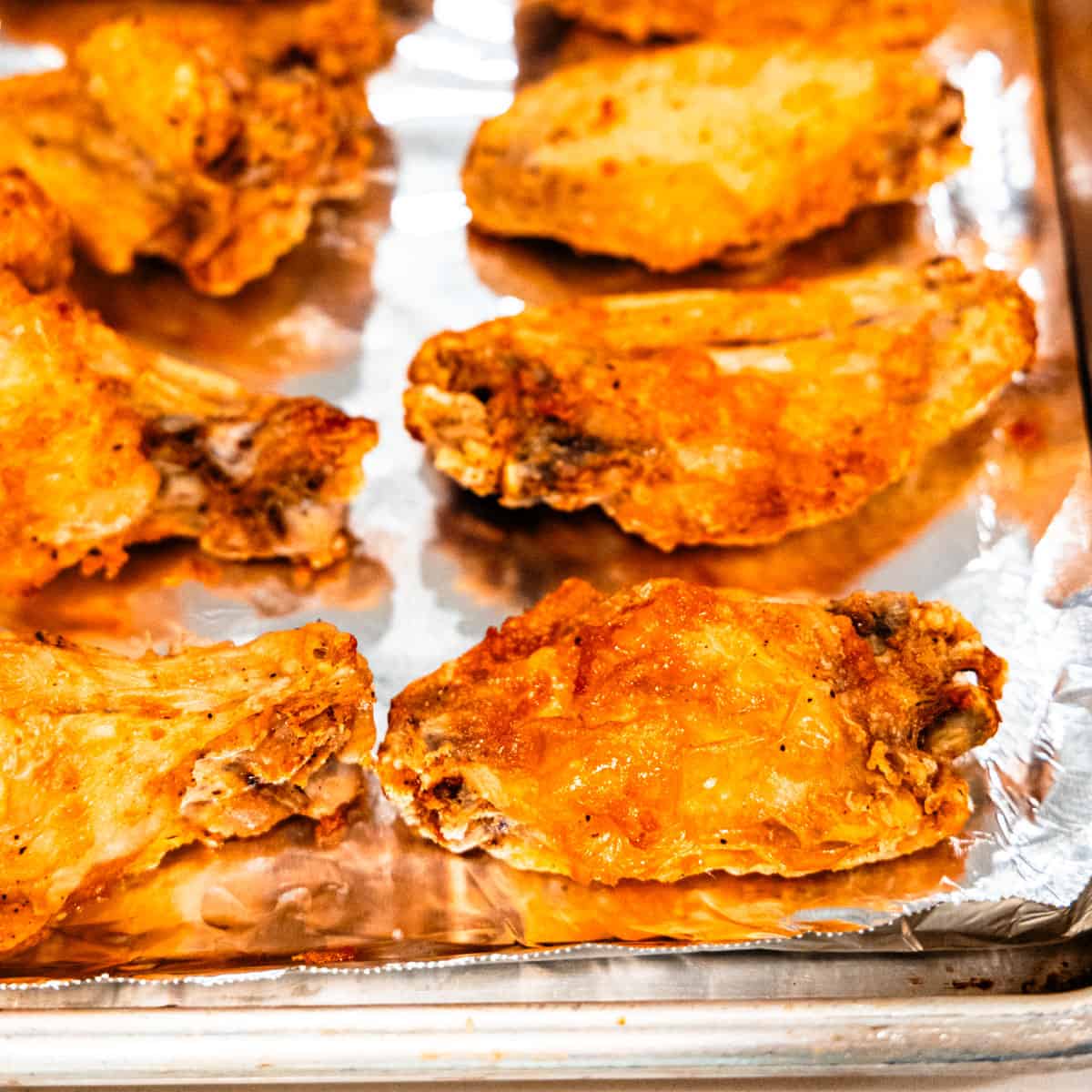 Crispy chicken wings on a baking sheet.