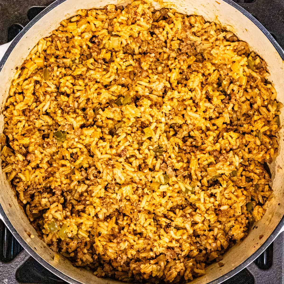 A finished pot of dirty rice on a stovetop.