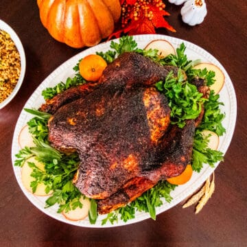 A whole roasted Cajun turkey served on a platter.