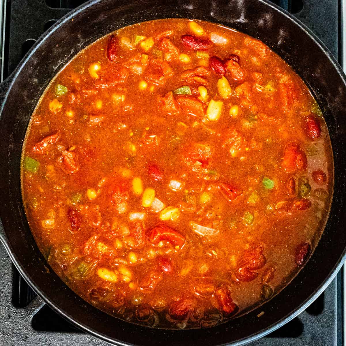 Chili in a large cast iron pot on a stovetop. 
