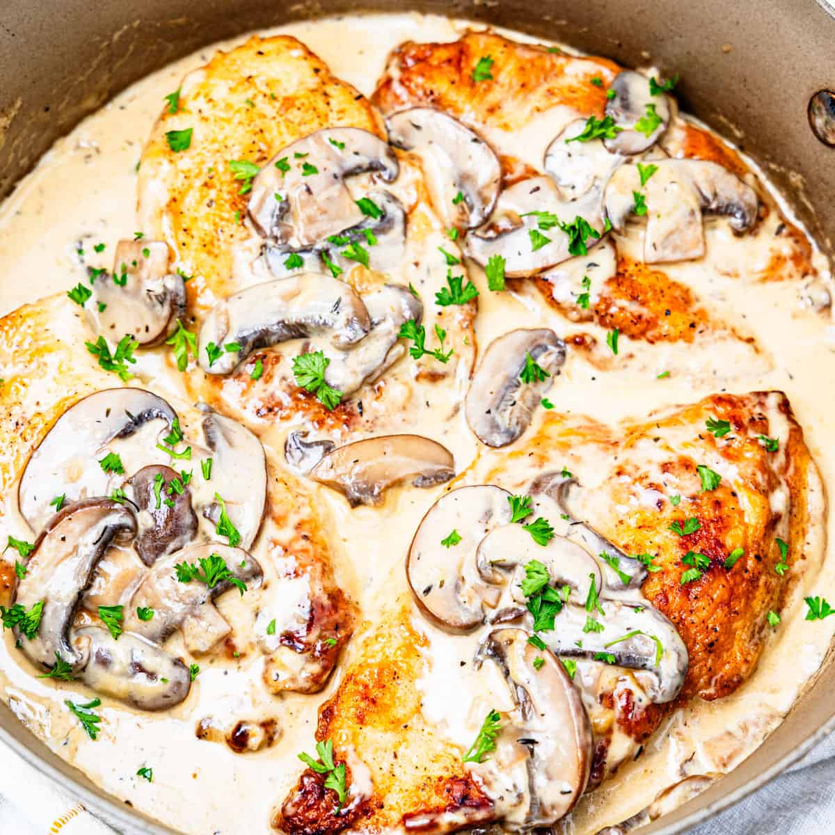 Chicken with cream of mushroom sauce in a pan.