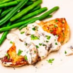 A chicken breast covered in mushroom cream sauce.