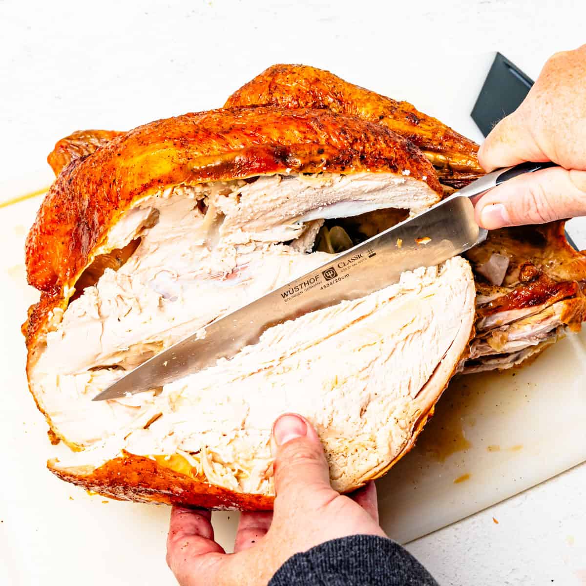 Carving a turkey breast off of a whole turkey.