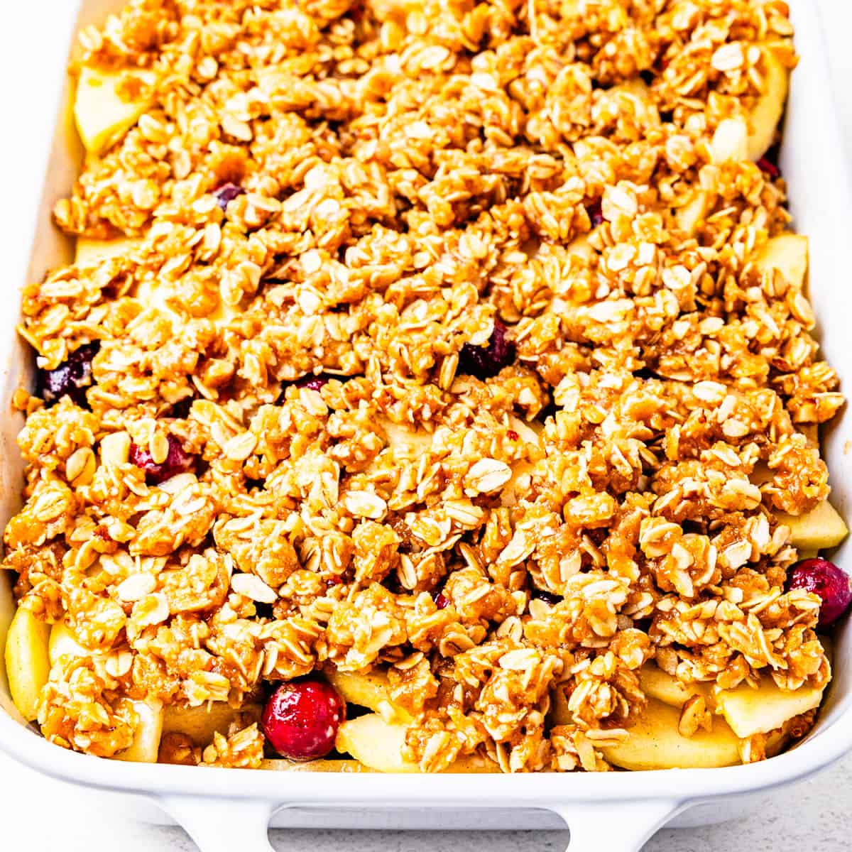 An unbaked apple crisp in a baking dish.