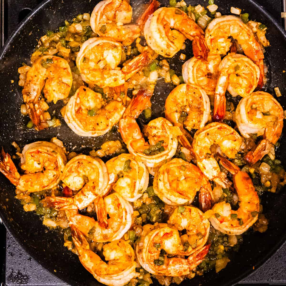 Cooked shrimp with vegetables in a large skillet. 