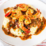 A serving of Cajun shrimp and grits on a plate.