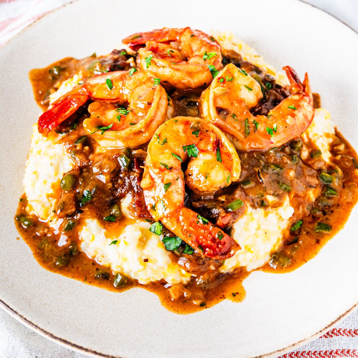 A serving of Cajun shrimp and grits on a plate.