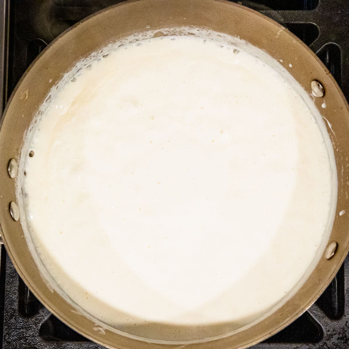 Cream sauce cooking in a pan.