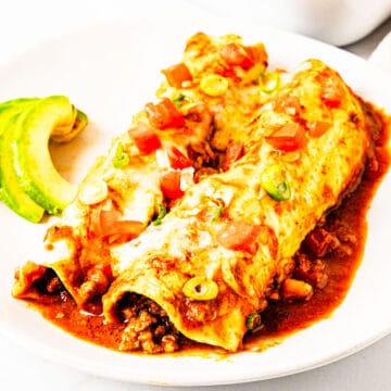 Ground beef and black bean enchiladas on a plate.