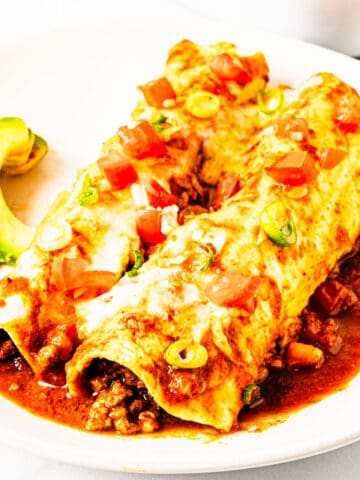 Ground beef and black bean enchiladas on a plate.