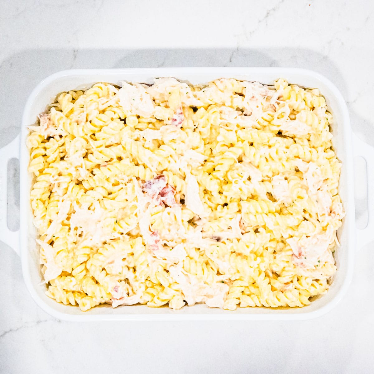 Chicken bacon ranch pasta in a baking dish before adding toppings.