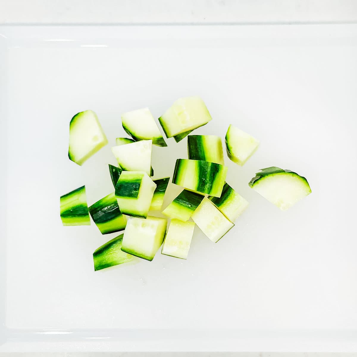 An English cucumber chopped on a cutting board.