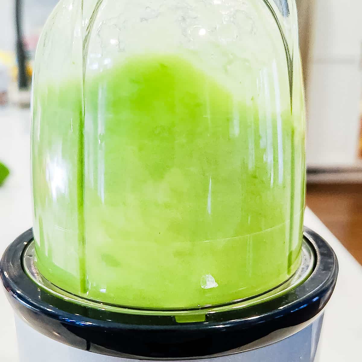Cucumber and lime juice being blended in a blender.
