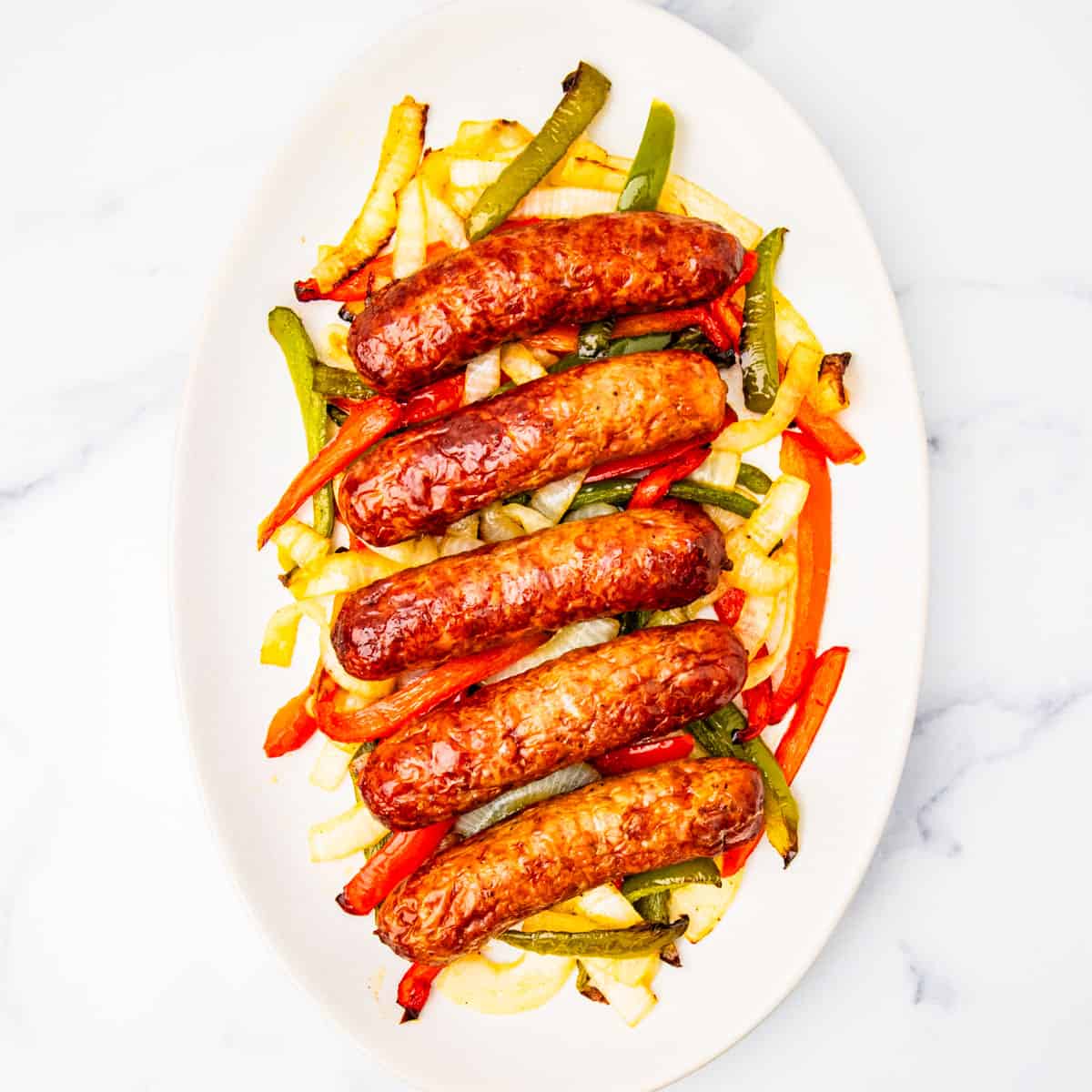 Italian sausages on a platter with peppers and onions.