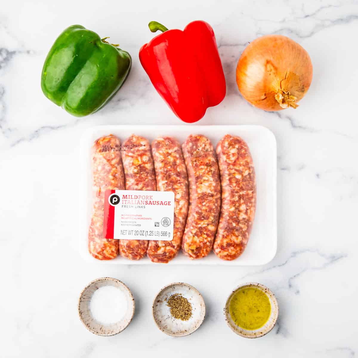 Ingredients for sausage and peppers arranged on a counterop.