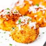 Arancini balls served on a platter with marinara sauce.
