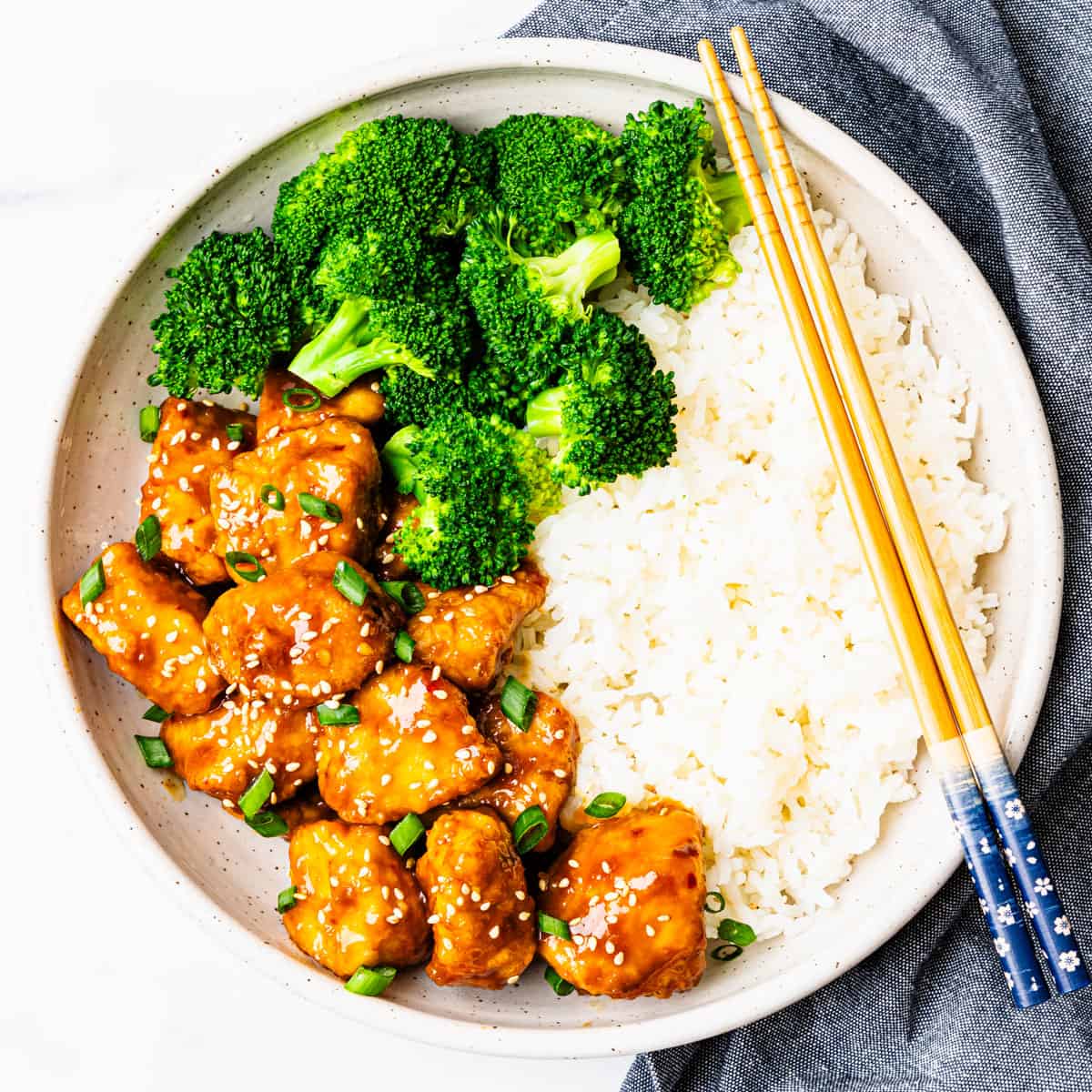 A serving of orange chicken with rice and broccoli. 