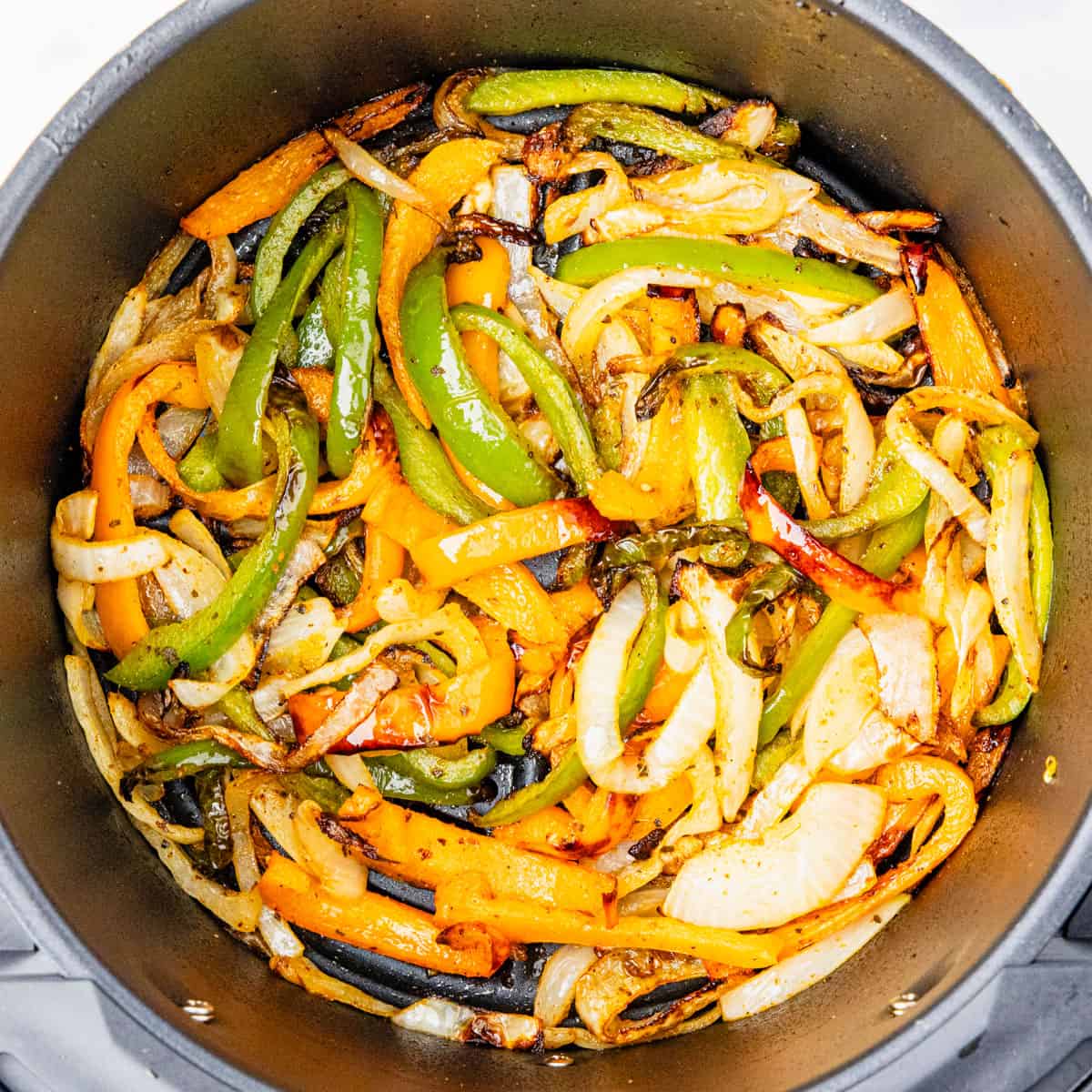 Cooked peppers and onions in an air fryer.