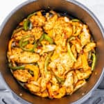 Chicken fajitas with peppers and onions in an air fryer.